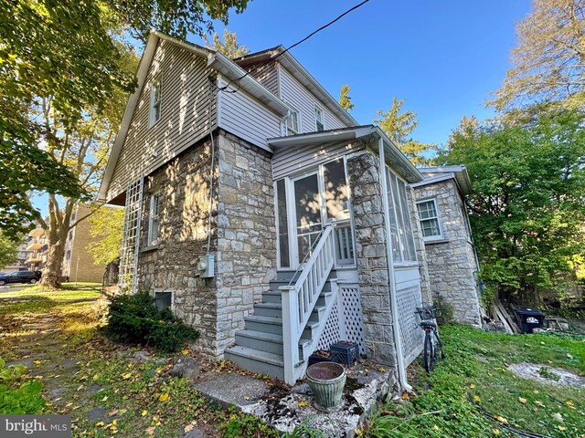 348 E Foster Ave, State College, PA 16801 - view of property exterior with stone siding, a sunroom, and stairs