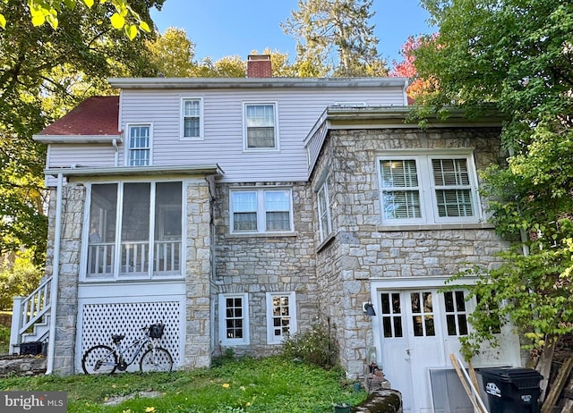 348 E Foster Ave, State College, PA 16801 - rear view of house with stone siding, a chimney, a sunroom, and stairs