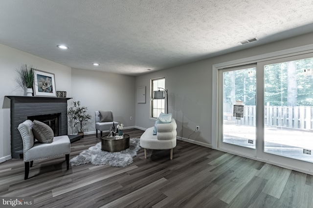 7910 Peyton Forest Trl, Annandale, VA 22003 - living area with wood finished floors, a textured ceiling, recessed lighting, a brick fireplace, and electric panel