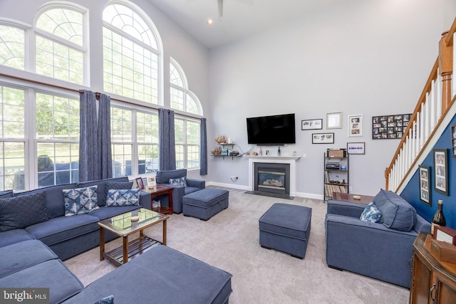 2200 Summerdale Ln, Linfield, PA 19468 - living area featuring a high ceiling, carpet, stairway, a fireplace with flush hearth, and baseboards