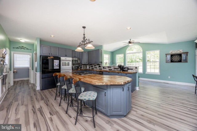 2200 Summerdale Ln, Linfield, PA 19468 - kitchen with butcher block countertops, stainless steel appliances, a breakfast bar, baseboards, and light wood finished floors