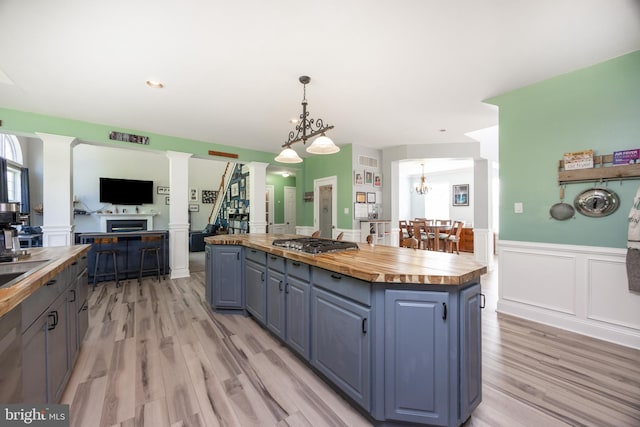 2200 Summerdale Ln, Linfield, PA 19468 - kitchen with wooden counters, stainless steel gas stovetop, a kitchen island, a fireplace, and light wood finished floors