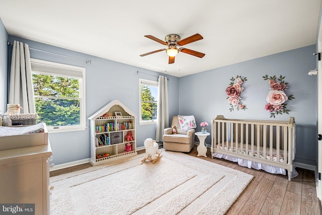 1576 Delong Dr, Downingtown, PA 19335 - bedroom featuring a nursery area, wood finished floors, ceiling fan, and baseboards