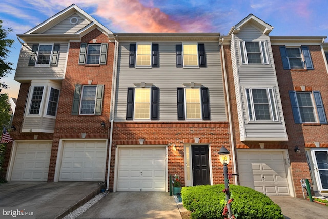 11917 Hayes Station Way, Manassas, VA 20109 - townhome / multi-family property with a garage, brick siding, and driveway