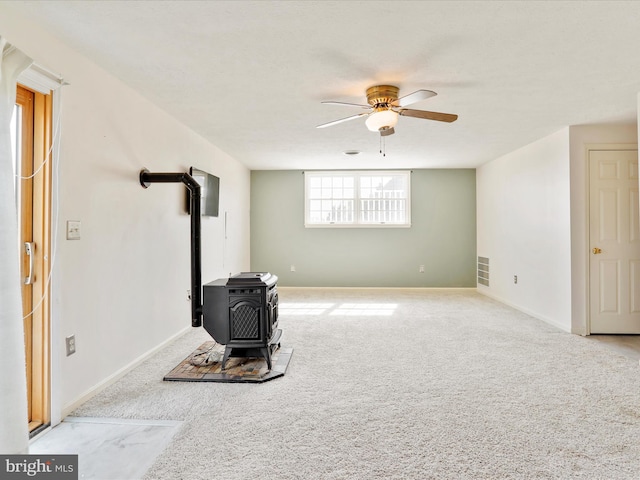 1204 S Fork Dr, Front Royal, VA 22630 - unfurnished living room featuring a wood stove, ceiling fan, carpet floors, and baseboards
