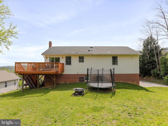 1204 S Fork Dr, Front Royal, VA 22630 - back of property featuring a deck, stairs, a trampoline, an outdoor fire pit, and a yard