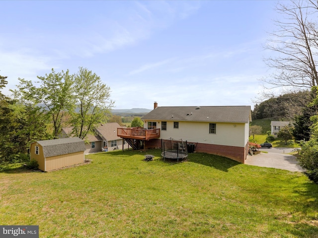 1204 S Fork Dr, Front Royal, VA 22630 - rear view of house featuring a trampoline, a wooden deck, a lawn, and a chimney