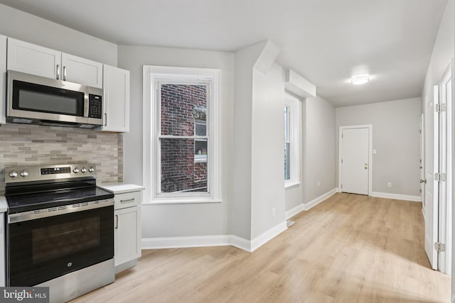 308 S 56th St, Philadelphia, PA 19143 - kitchen with stainless steel appliances, light wood-style flooring, backsplash, and light countertops