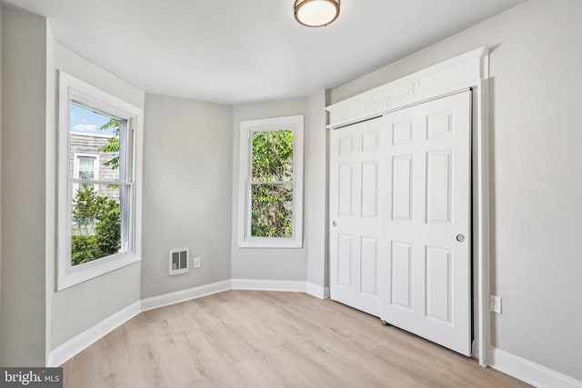 308 S 56th St, Philadelphia, PA 19143 - unfurnished bedroom featuring light wood-style floors, multiple windows, and baseboards