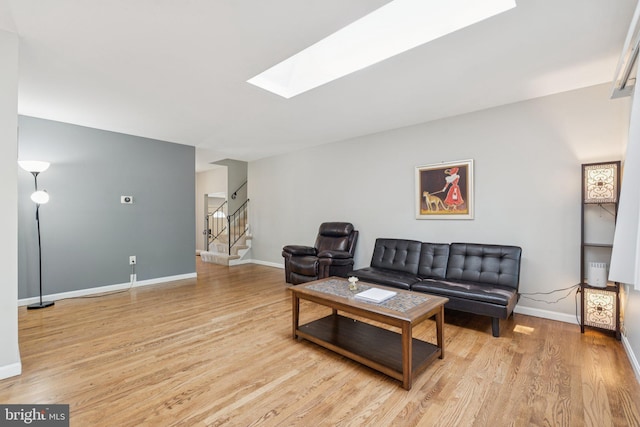 9207 Bois Ave, Vienna, VA 22182 - living room featuring a skylight, light wood-style flooring, and stairway