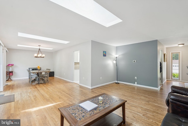 9207 Bois Ave, Vienna, VA 22182 - living room featuring a skylight, a chandelier, and light wood-type flooring