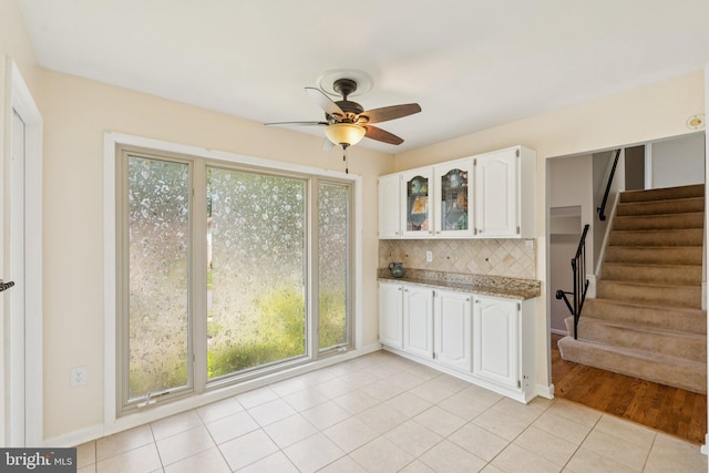 9207 Bois Ave, Vienna, VA 22182 - kitchen featuring white cabinets, ceiling fan, decorative backsplash, glass insert cabinets, and light tile patterned flooring