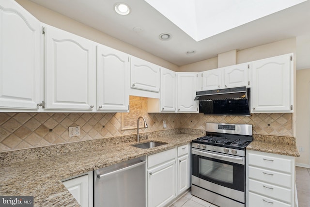 9207 Bois Ave, Vienna, VA 22182 - kitchen featuring stainless steel appliances, under cabinet range hood, white cabinetry, light tile patterned flooring, and light stone counters