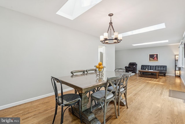 9207 Bois Ave, Vienna, VA 22182 - dining space with a skylight, a chandelier, and light wood finished floors
