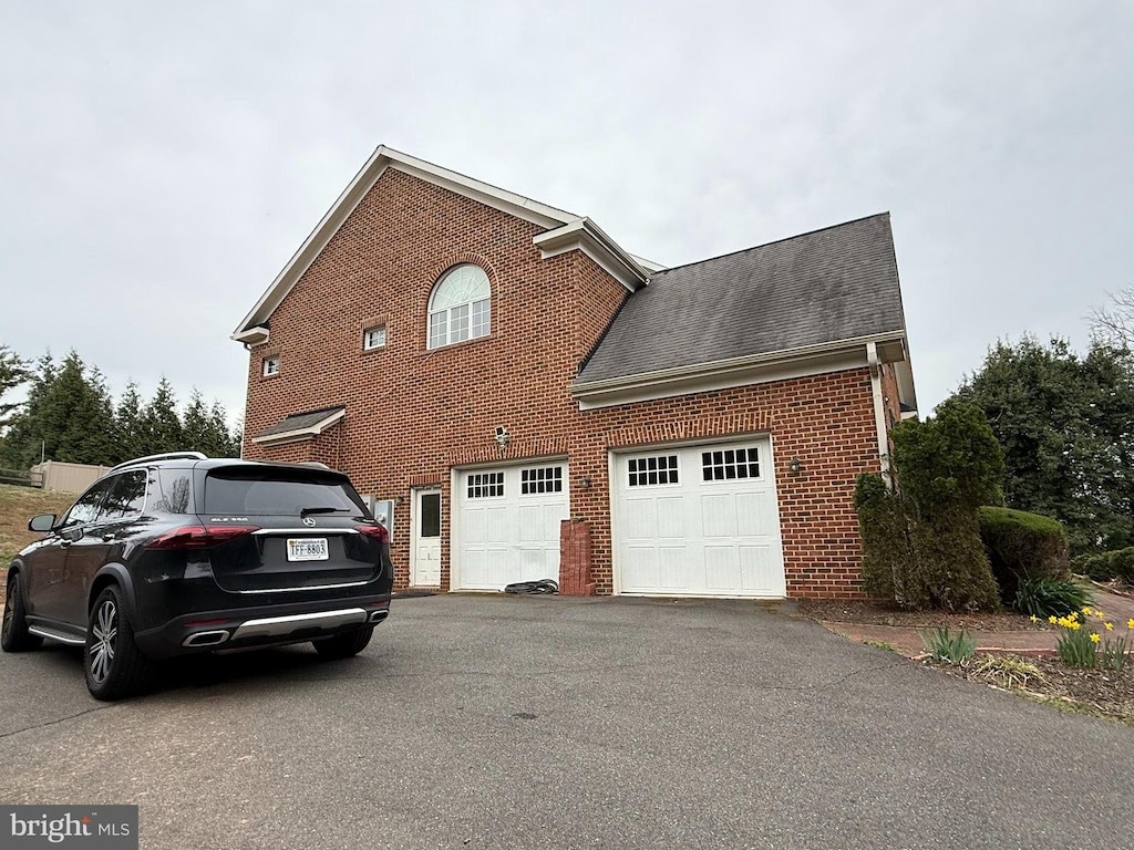 6634 Brawner St, Mclean, VA 22101 - view of side of property featuring asphalt driveway, brick siding, and roof with shingles
