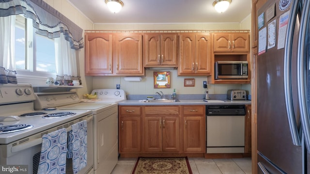 126 Heartwood Rd, Levittown, PA 19056 - kitchen with appliances with stainless steel finishes, a sink, light countertops, separate washer and dryer, and ornamental molding