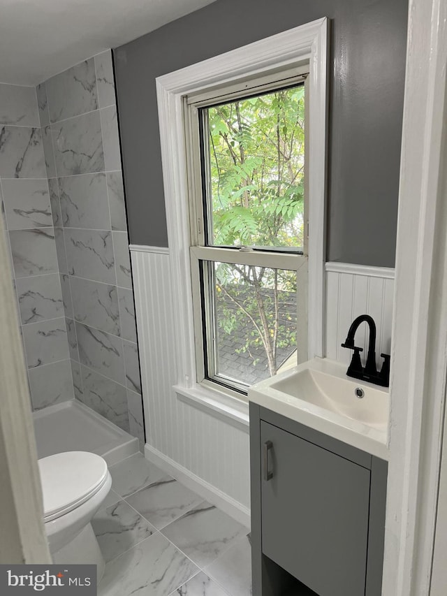 1105 N Chestnut St, Paulsboro, NJ 08066 - full bathroom with marble finish floors, wainscoting, vanity, toilet, and a tile shower
