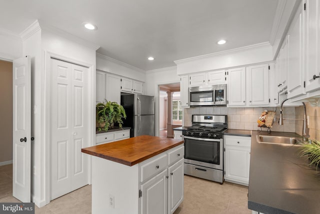 4849 Carriagepark Rd, Fairfax, VA 22032 - kitchen with appliances with stainless steel finishes, butcher block countertops, a sink, a kitchen island, and white cabinetry