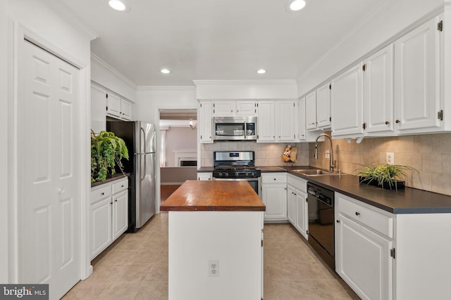 4849 Carriagepark Rd, Fairfax, VA 22032 - kitchen with appliances with stainless steel finishes, a sink, butcher block countertops, a center island, and white cabinets