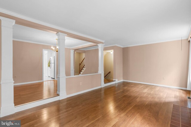 4849 Carriagepark Rd, Fairfax, VA 22032 - unfurnished living room with wood finished floors, baseboards, ornamental molding, stairway, and decorative columns