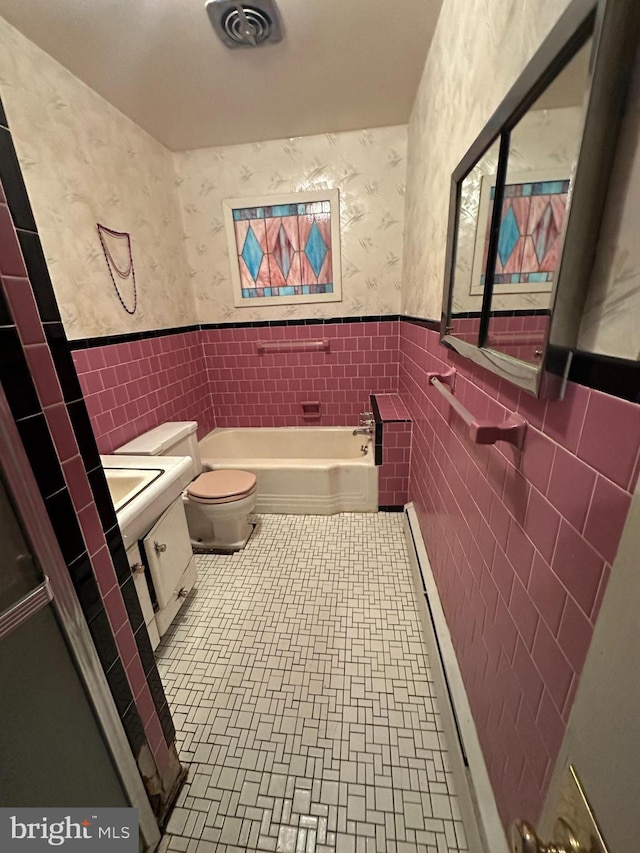 638 Washington St, Cumberland, MD 21502 - full bathroom featuring tile walls, wallpapered walls, a bath, wainscoting, and toilet