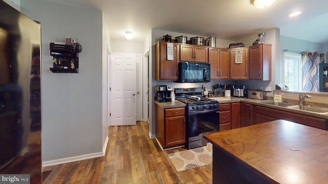 69 Geisinger Ln, Lewistown, PA 17044 - kitchen featuring black microwave, stainless steel gas stove, a sink, dark wood-style flooring, and baseboards