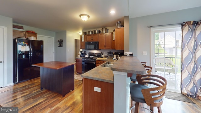 69 Geisinger Ln, Lewistown, PA 17044 - kitchen with black appliances, a sink, a kitchen breakfast bar, and dark wood finished floors