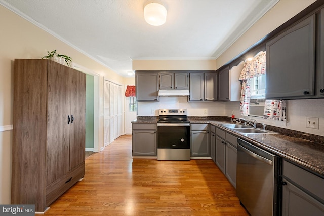 108 Oakmont Cir, Winchester, VA 22602 - kitchen with stainless steel appliances, under cabinet range hood, crown molding, dark countertops, and light wood-style floors