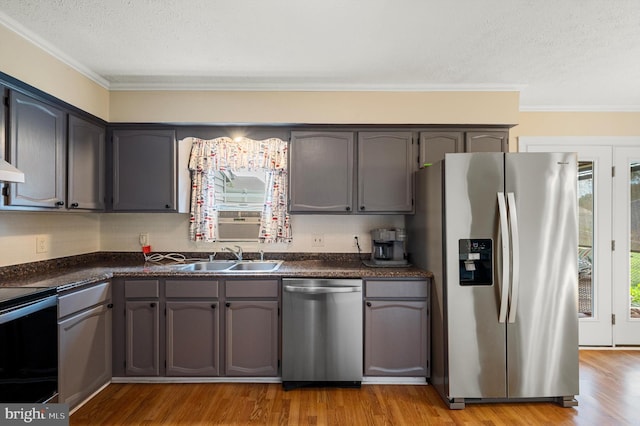 108 Oakmont Cir, Winchester, VA 22602 - kitchen with stainless steel appliances, dark countertops, a textured ceiling, crown molding, and light wood-type flooring