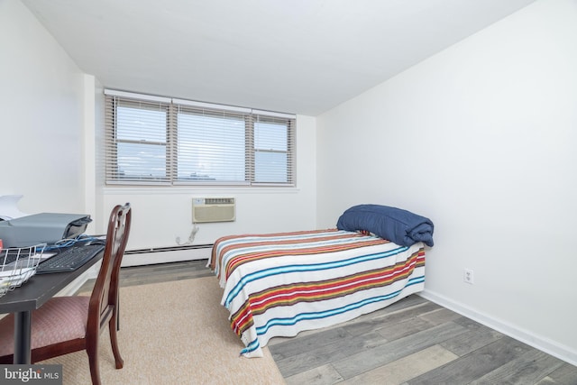 1301 N Harrison St Unit 1108, Wilmington, DE 19806 - bedroom featuring wood finished floors, baseboard heating, a wall unit AC, and baseboards