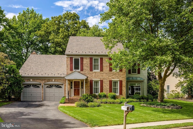 2982 Franklin Oaks Dr, Herndon, VA 20171 - view of front facade with a high end roof, asphalt driveway, an attached garage, brick siding, and a front lawn