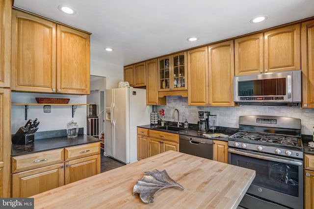 5901 Wivenhoe Ct, Alexandria, VA 22315 - kitchen featuring stainless steel appliances, wooden counters, a sink, glass insert cabinets, and tasteful backsplash