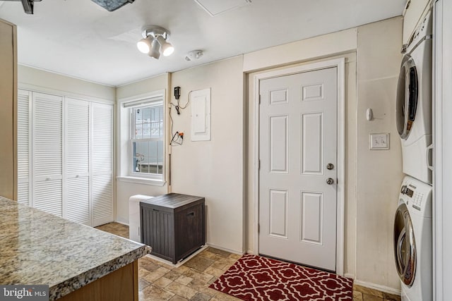 5901 Wivenhoe Ct, Alexandria, VA 22315 - laundry room with stacked washing machine and dryer, stone finish floors, electric panel, and baseboards
