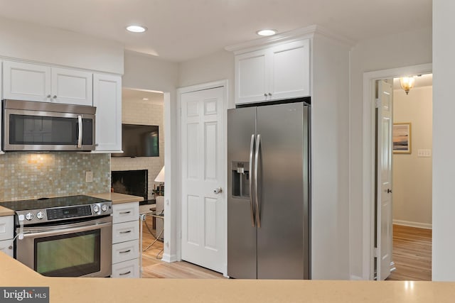 2657 Carrollton Rd, Annapolis, MD 21403 - kitchen featuring appliances with stainless steel finishes, white cabinets, tasteful backsplash, light wood-type flooring, and recessed lighting
