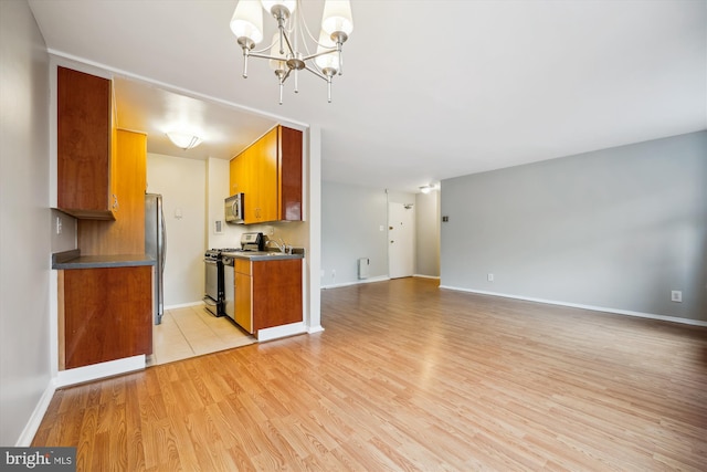 8601 Manchester Rd Unit 319, Silver Spring, MD 20901 - kitchen featuring stainless steel appliances, a chandelier, brown cabinets, light wood finished floors, and open floor plan