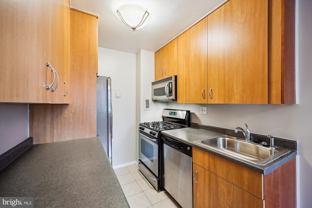 8601 Manchester Rd Unit 319, Silver Spring, MD 20901 - kitchen featuring stainless steel appliances, dark countertops, light tile patterned flooring, and brown cabinets