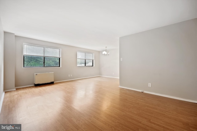 8601 Manchester Rd Unit 319, Silver Spring, MD 20901 - empty room with radiator heating unit, a chandelier, and light wood-type flooring