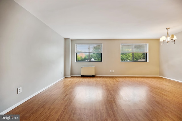 8601 Manchester Rd Unit 319, Silver Spring, MD 20901 - empty room featuring radiator heating unit, plenty of natural light, a chandelier, and light wood-style flooring