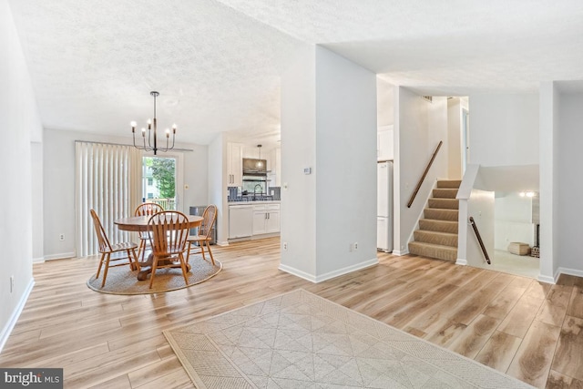 111 Sue Ann Ct, Sterling, VA 20164 - dining space featuring a chandelier, light wood-type flooring, a textured ceiling, and stairway