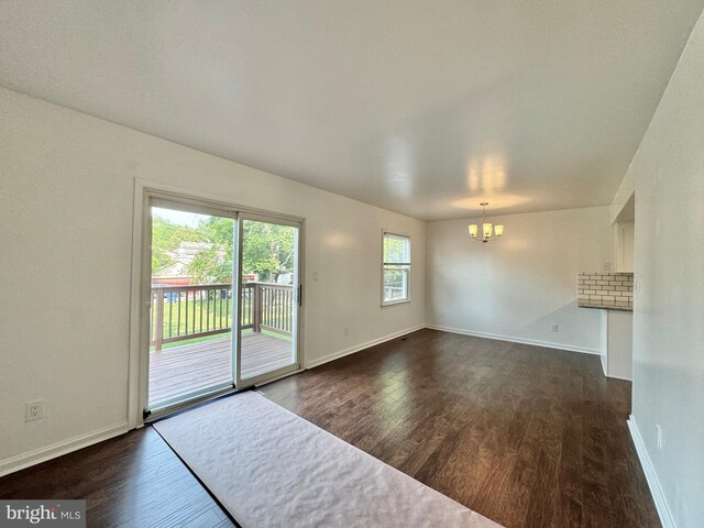 225 N New St, Dover, DE 19904 - unfurnished living room with a chandelier and dark wood-style flooring