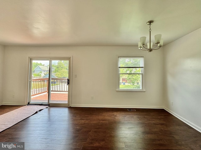 225 N New St, Dover, DE 19904 - empty room featuring plenty of natural light, a chandelier, and dark wood-style flooring