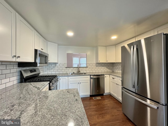 225 N New St, Dover, DE 19904 - kitchen featuring appliances with stainless steel finishes, backsplash, dark wood-style flooring, white cabinets, and recessed lighting