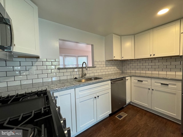 225 N New St, Dover, DE 19904 - kitchen with stainless steel appliances, white cabinets, dark wood finished floors, light stone countertops, and recessed lighting