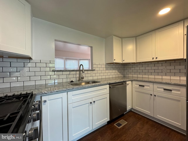 225 N New St, Dover, DE 19904 - kitchen with dishwasher, dark wood-type flooring, white cabinetry, and light stone counters