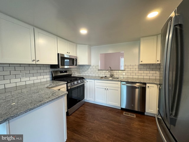 225 N New St, Dover, DE 19904 - kitchen featuring stainless steel appliances, white cabinetry, decorative backsplash, dark wood-style flooring, and recessed lighting
