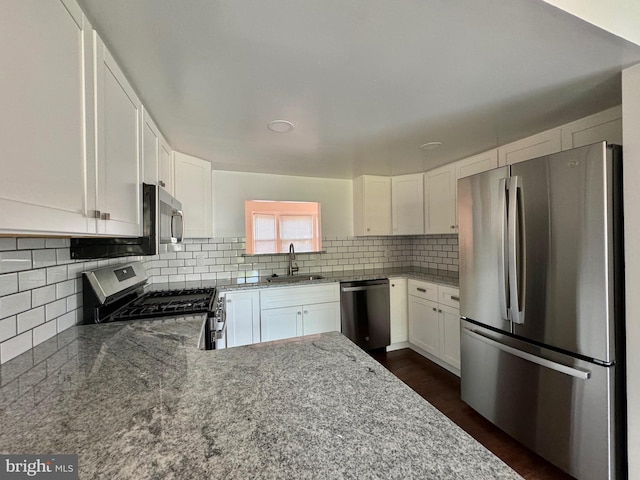225 N New St, Dover, DE 19904 - kitchen featuring appliances with stainless steel finishes, decorative backsplash, light stone countertops, and white cabinetry