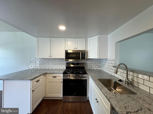 225 N New St, Dover, DE 19904 - kitchen featuring stainless steel appliances, a peninsula, light stone countertops, white cabinets, and recessed lighting