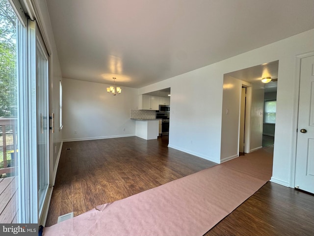 225 N New St, Dover, DE 19904 - unfurnished living room with a chandelier and dark wood finished floors