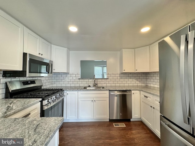 225 N New St, Dover, DE 19904 - kitchen with stainless steel appliances, white cabinets, backsplash, and recessed lighting