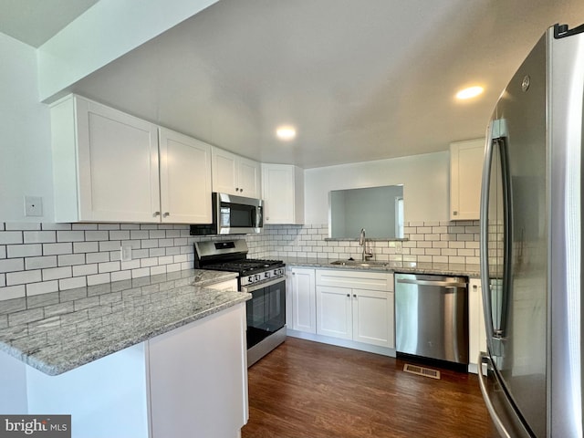 225 N New St, Dover, DE 19904 - kitchen with appliances with stainless steel finishes, light stone counters, white cabinetry, a peninsula, and recessed lighting